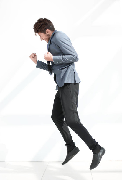 business style. Handsome young man in full suit jumping against  - Фото, зображення