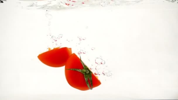 Snij groenten tomaten snel in water van bubbels, Slowmotion close-up zinken - Video