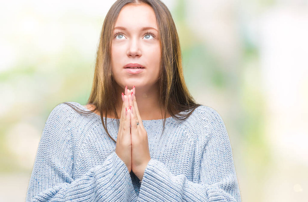 Mladá krásná Kavkazský žena nosí zimní svetr izolované pozadí prosit a modlit se s rukama naděje výraz na tváři velmi emocionální a strach. Žádá o odpuštění. Pojem náboženství. - Fotografie, Obrázek