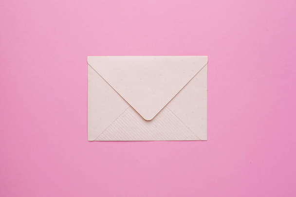 Closed envelope on a pink background top view - Фото, изображение