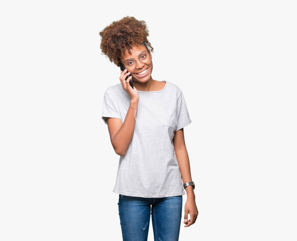 Young african american woman talking on smartphone over isolated background with a happy face standing and smiling with a confident smile showing teeth - Foto, afbeelding