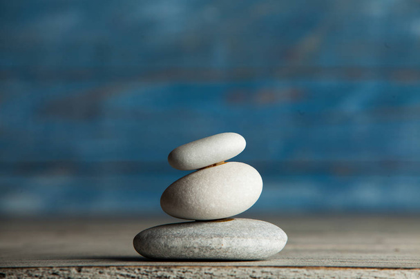 Rzeźba Zen. Harmonii i równowagi, cairn, opanowanie kamienie na drewnianym stole. - Zdjęcie, obraz