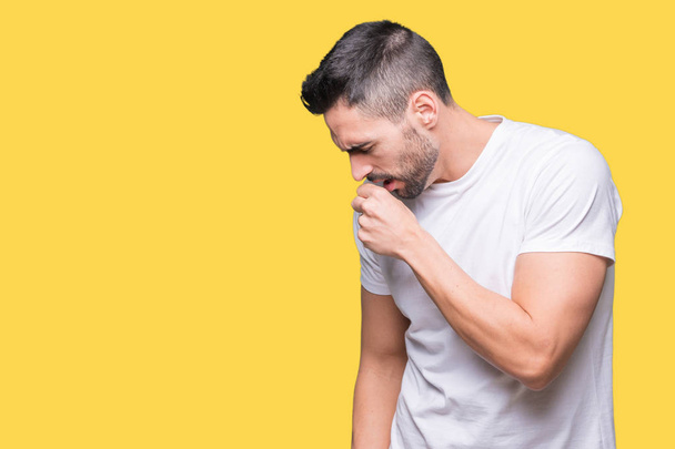 Giovane uomo che indossa casual t-shirt bianca su sfondo isolato sensazione di malessere e tosse come sintomo per il freddo o bronchite. Concetto sanitario
. - Foto, immagini