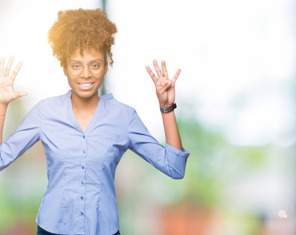 Γυναίκα όμορφη νεαρή αφρικανική αμερικανική επιχείρηση πέρα από το απομονωμένο υπόβαθρο δείχνει και δείχνει προς τα επάνω με τα δάχτυλα τον αριθμό εννέα ενώ χαμογελώντας αυτοπεποίθηση και χαρούμενοι. - Φωτογραφία, εικόνα