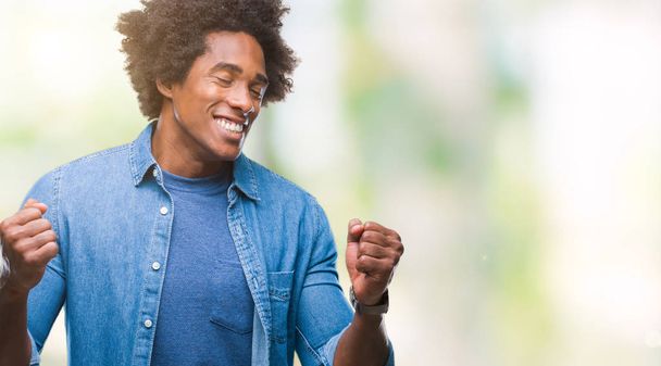 Afro american man over isolated background very happy and excited doing winner gesture with arms raised, smiling and screaming for success. Celebration concept. - Photo, Image