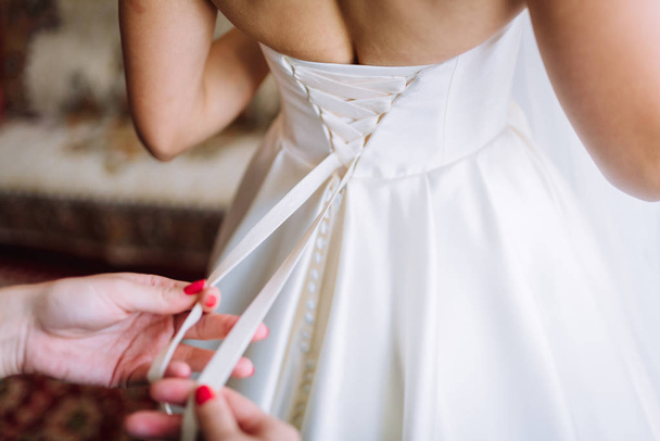 the bride is knotted with a dress on her back. soft focus - Fotoğraf, Görsel