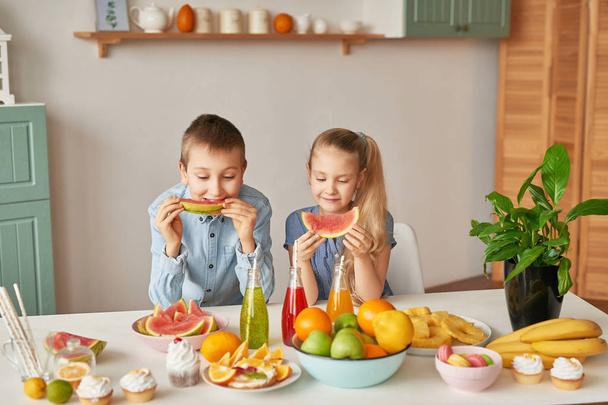 дети на кухне в пасхальный день, мальчик и девочка с пасхальными пряниками и яйцами
 - Фото, изображение