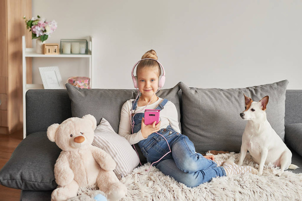 dívka ve sluchátkách poslouchá hudbu doma - Fotografie, Obrázek