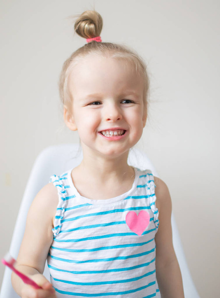 Счастливая маленькая девочка чистит зубы, розовая зубная щетка, зубная гигиена, утренняя ночь Здоровый концепт образа жизни
 - Фото, изображение