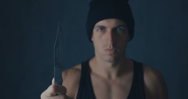 Portret van gevaarlijke man in een dop met een mes - Video