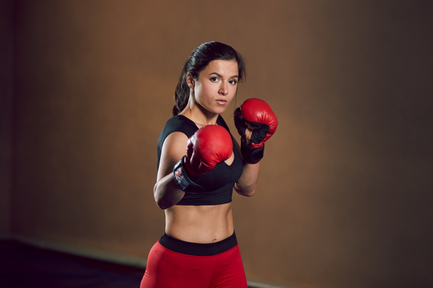 Young athletic girl fighter trains in the gym. - Photo, Image