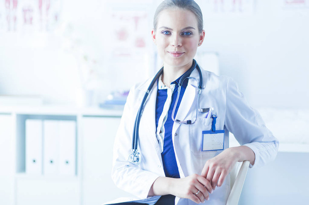 Портрет молодой женщины-врача, сидящей за столом в больнице - Фото, изображение