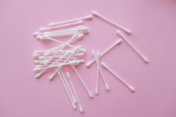 white plastic cotton buds on a pink background, Flat lay, view from above - Photo, Image