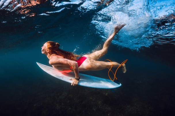 Attractive surfer woman dive underwater under wave. - Photo, Image