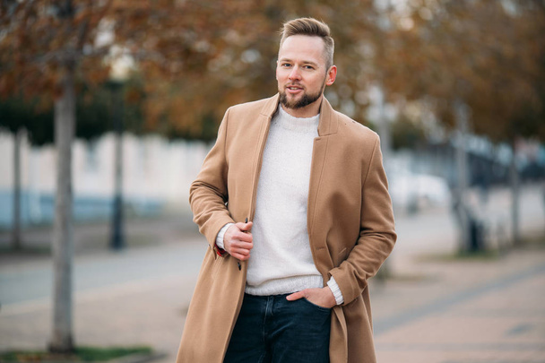 Portrait of confident man in brown coat and white sweater. - Foto, Imagem