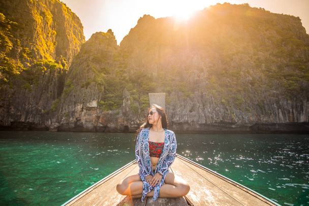 マヤ ・ ベイ、ピピ島、タイのプーケットでロングテール ボートでリラックス若いアジア女性 - 写真・画像