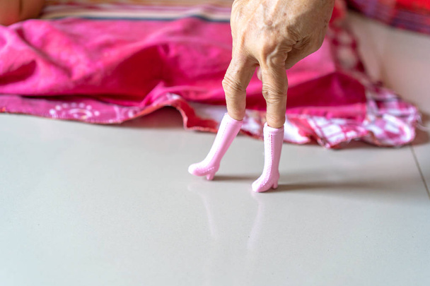 Стара жінка грає в рожеві пластикові черевики і розміщує їх, як пост моделі
. - Фото, зображення