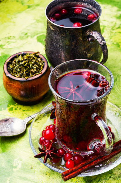 Зимний горячий чай с ягодами и специями в стеклянной чашке
 - Фото, изображение