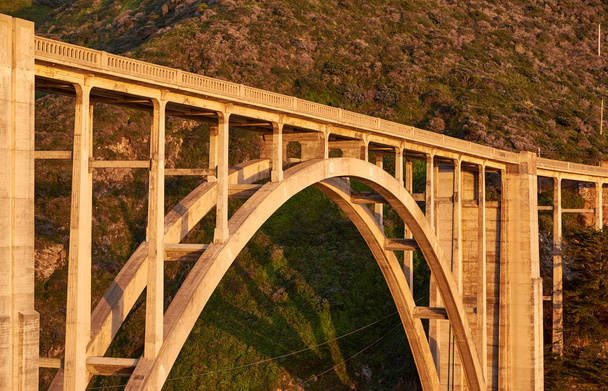Γέφυρα Μπίξμπι Κρικ στον αυτοκινητόδρομο 1 το ηλιοβασίλεμα. Big Sur Area, Καλιφόρνια, ΗΠΑ. - Φωτογραφία, εικόνα