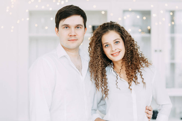 Young couple eating sweets at the table. Photo shoot in a bright interior Studio for the New year. - Fotó, kép