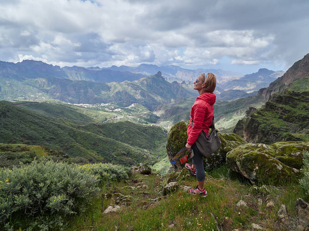 Young woman tourist standing on cliff's edge admiring landscape, Gran Canaria, Spain - Photo, image