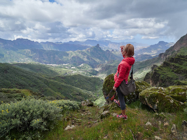 Young woman tourist standing on cliff's edge admiring landscape, Gran Canaria, Spain - Photo, Image