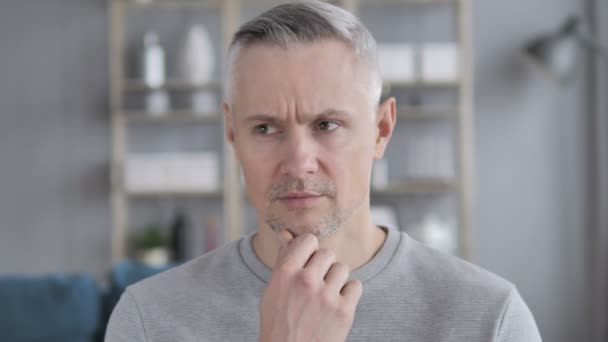 Porträt eines denkenden Mannes mittleren Alters mit grauen Haaren - Filmmaterial, Video