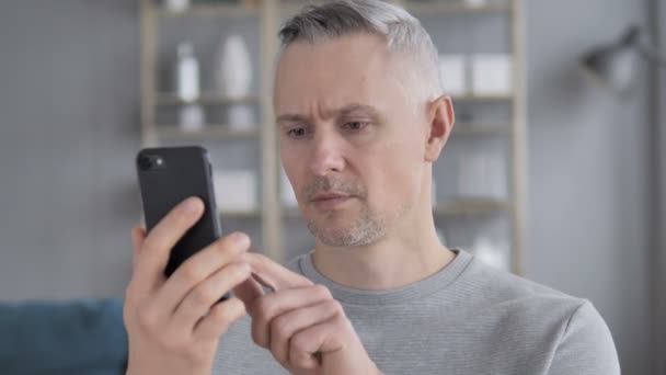 Szürke haj férfi sokkos állapotban, miközben használ Smartphone, tragédia - Felvétel, videó