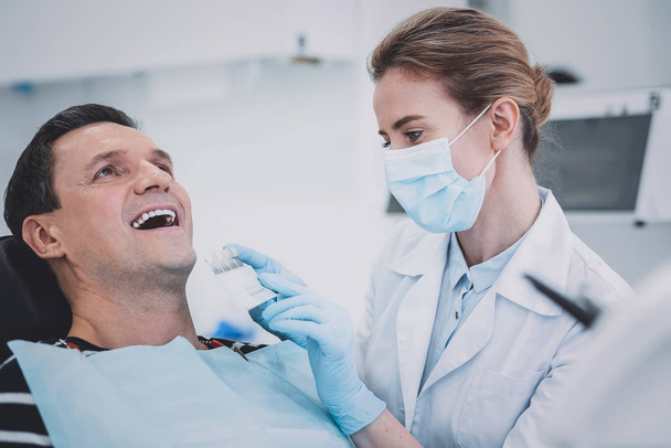 Attentive stomatologist doing teeth examination in clinic - Foto, Imagem