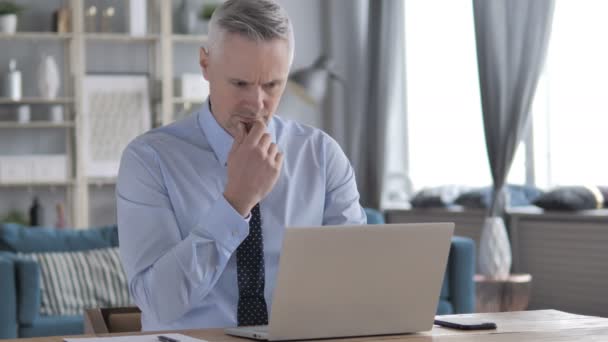 Zamyšlený šedivé vlasy podnikatel přemýšlet a pracovat na notebooku - Záběry, video
