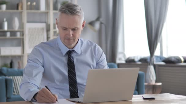 Grijze haren zakenman schrijven op papier op het werk, administratie - Video