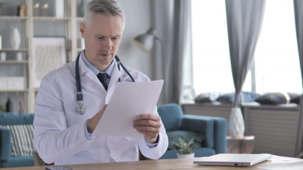 Senior Doctor Reading Medical Report in Clinic - Záběry, video