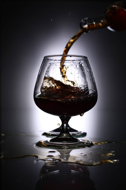 Versare il brandy in un bicchiere
 - Foto, immagini