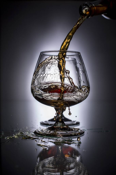 Versare il brandy in un bicchiere
 - Foto, immagini
