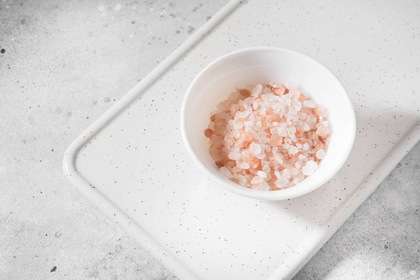 Pink sea salt on a light gray background - Foto, Imagen