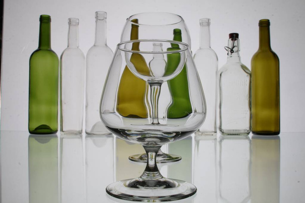 sklenice a láhve brandy a víno v pozadí - Fotografie, Obrázek
