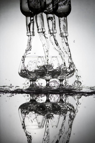 glazen en flessen voor brandy en wijn in de achtergrond - Foto, afbeelding