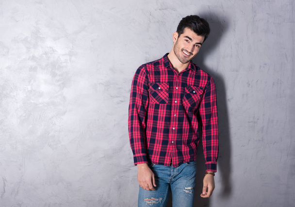 A happy young man in a red checkered shirt - Φωτογραφία, εικόνα