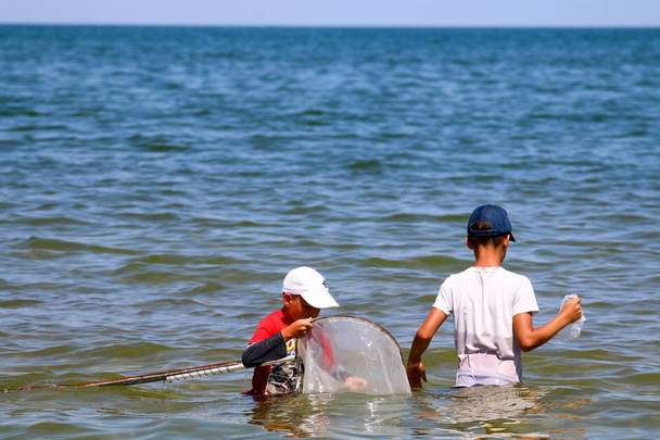 İki balıkçı çocuk karides ve midye yakalamak - Fotoğraf, Görsel