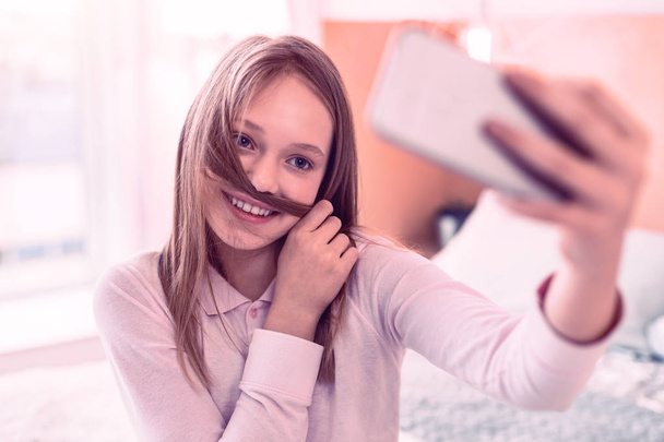 Nice smiling teenager having fun doing selfies - Foto, Imagem