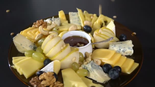 Cheese platter sprinkled with pine nuts. slow motion - Footage, Video