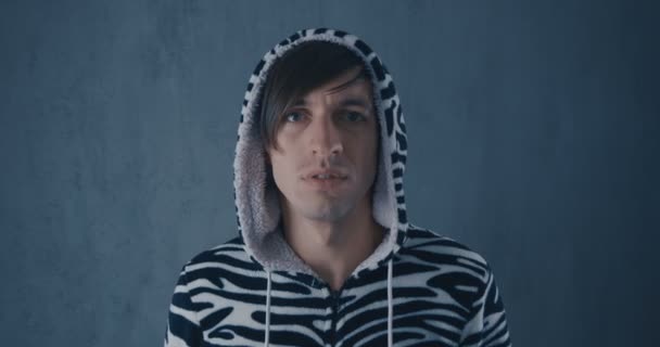 Porträt eines jungen Mannes in kigurumi Zebras auf grauem Hintergrund. - Filmmaterial, Video