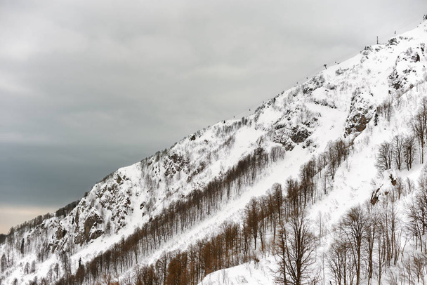 Snow-covered slope of the mountain on a cloudy da - Foto, Bild