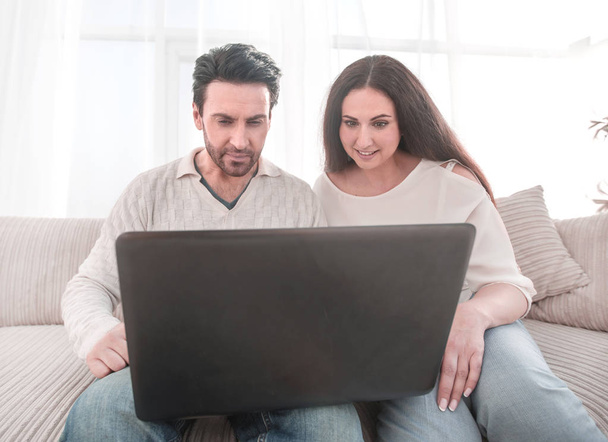 married couple watching a show on their laptop - Photo, Image