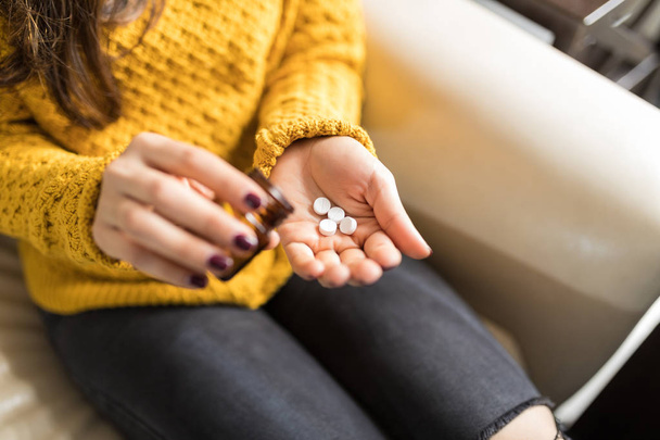 Midsection de la femme dans les occasionnels verser des pilules à la maison
 - Photo, image