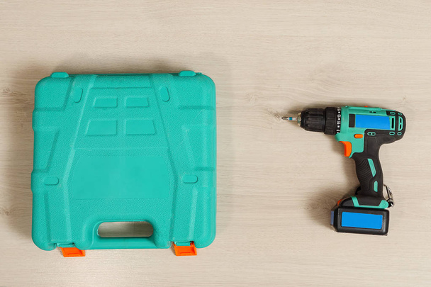 Drill and plastic case on wood - 写真・画像