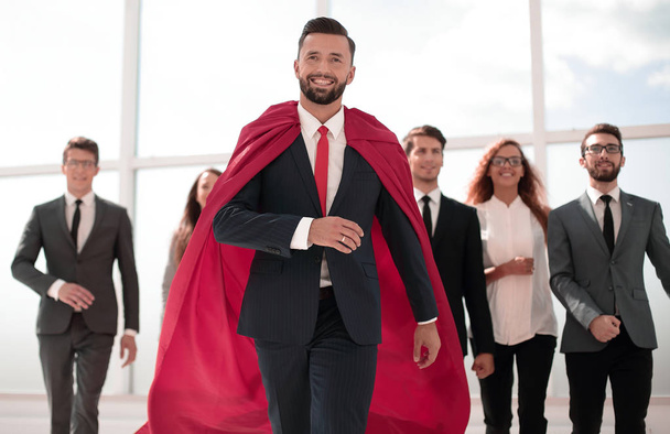 businessman is a superhero, stepping ahead of his business team - Photo, image