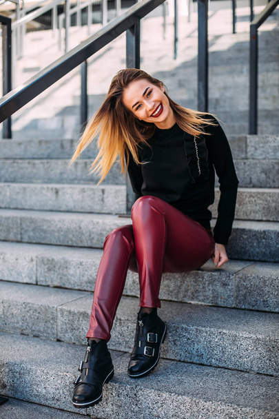 young attractive stylish smiling woman having fun in city , positive, emotional, wearing leather shorts and black sweatshirt bright red lips. style fashion trend. - Foto, Bild