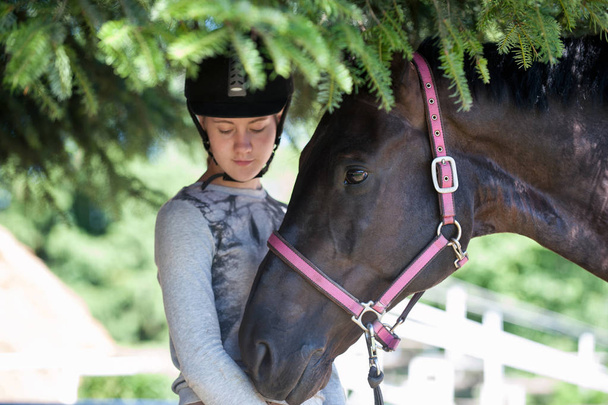 Portret z kasztanów horse głowy wraz z jej właściciel młode nastoletnie dziewczyny jeździectwo. Kolorowe lato na zewnątrz poziome obrazu. - Zdjęcie, obraz