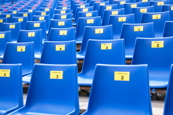 rij van blauwe plastic stoelen - Foto, afbeelding